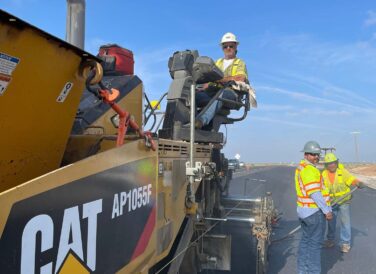 construction workers paving road at SH 302